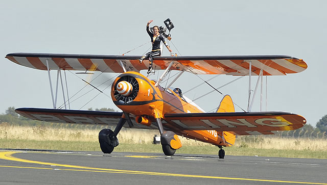 Boeing Stearman of AeroSuperBatics, painted in Breitling colors, performing wing walking at an air show